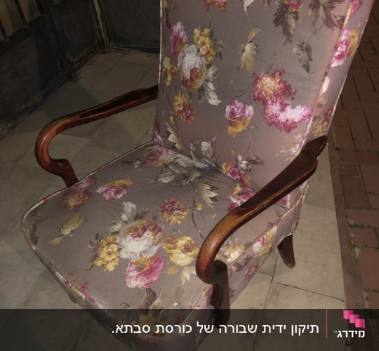כורסה מרופדת בבד פרחוני צבעוני עם ידיות עץ
